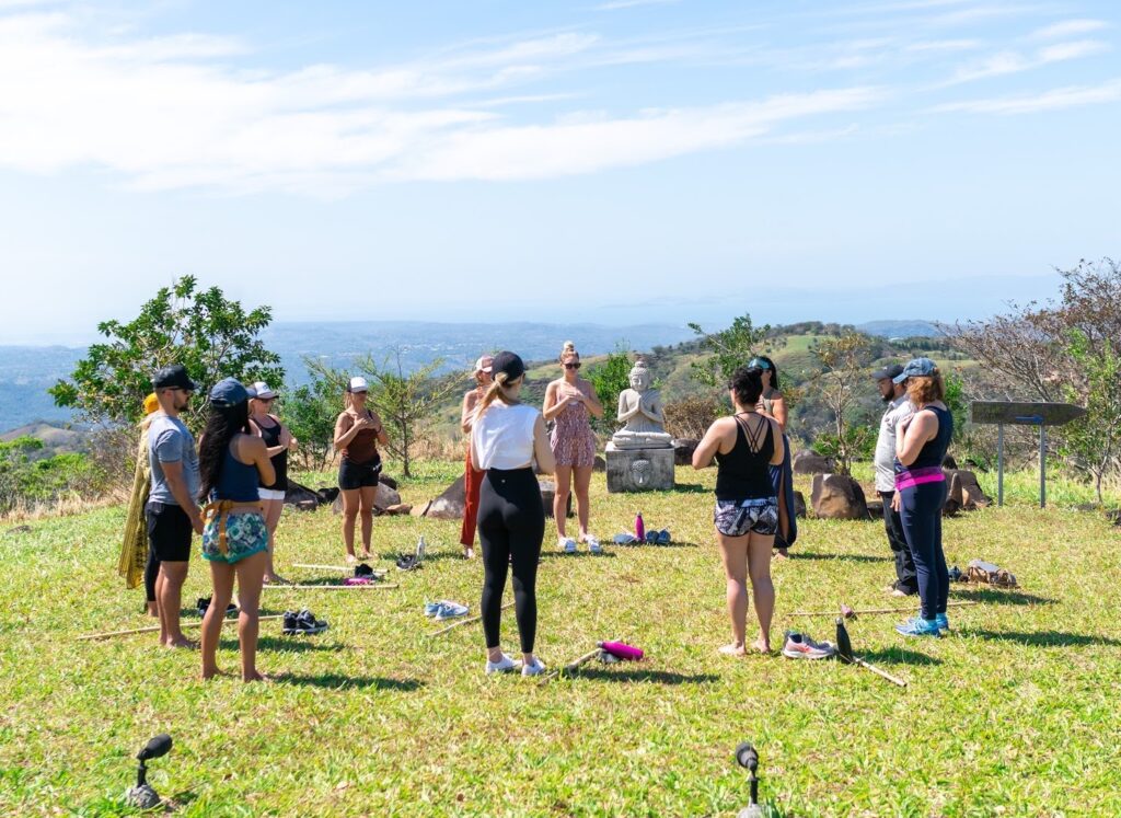 Circle of women meditating on grass to ground root chakras